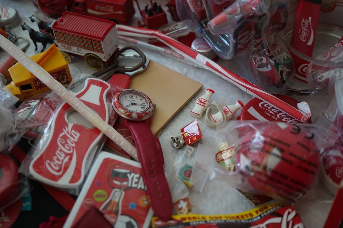 Man sieht Daniel Jaussi und seine Coca-Cola Sammlung.